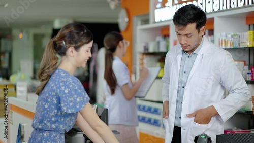 caucasian male pharmacist explaining the medicinal properties on the pillbox to a patient or customer according to the doctor's prescription and providing customers with e-service payment at the custo photo