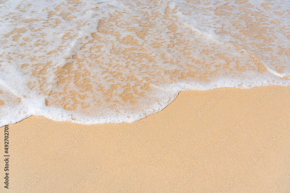 Top view of soft wave on sandy beach. Copy space