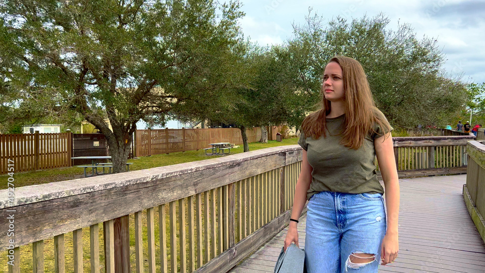 Young woman walks across a jetty in the Everglades - travel photography Young woman walks across a jetty in the Everglades - travel photography