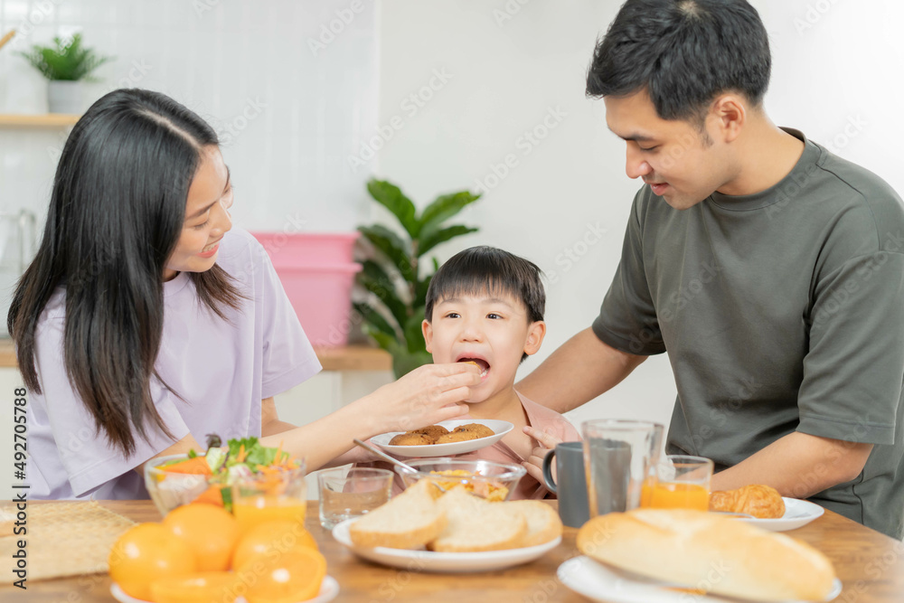 Happy refreshment family breakfast in morning, asian young parent father, mother and little cute boy, child having meal in kitchen eating together at home. Cheerful, enjoy cooking people. Happy refreshment family breakfast in morning, asian young parent father, mother and little cute boy, child having meal in kitchen eating together at home. Cheerful, enjoy cooking people.