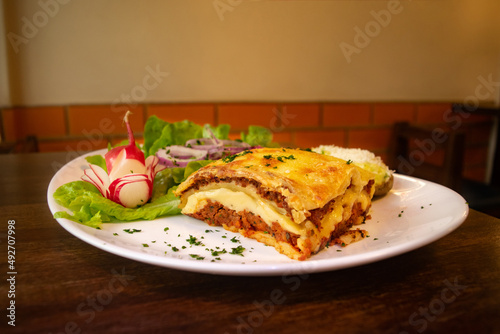 lasagna on a plate with salad
