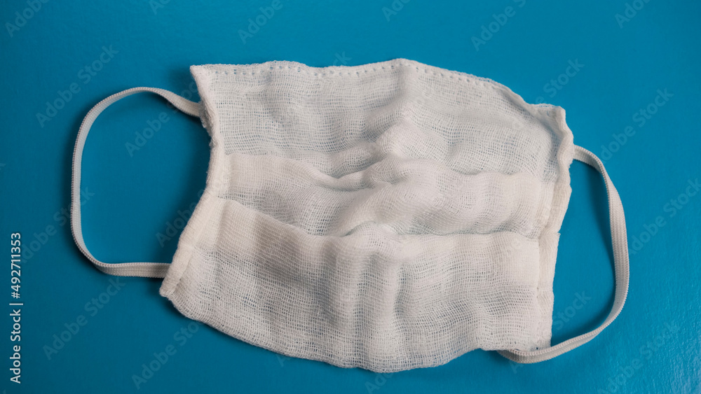 Cotton gauze surgical mask, isolated on blue background Cotton gauze surgical mask, isolated on blue background