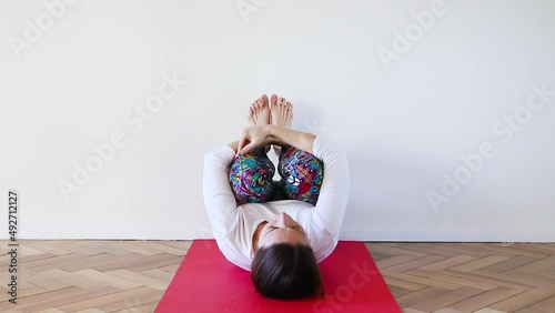 Caucasian young woman on Balasana, inverted child's yoga pose in interior room