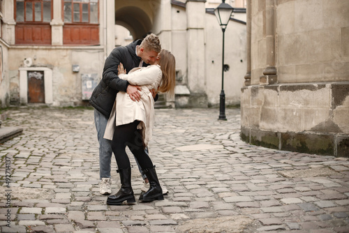 Romantic couple hugging and kissing in the street of old town