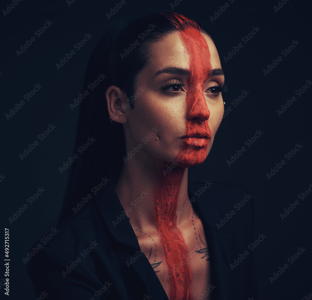 I call you beautiful, but you are more than amazing. Studio shot of a young woman posing with paint on her face on a black background.