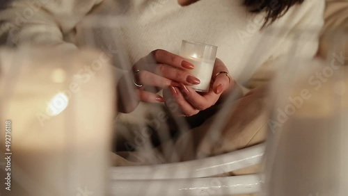 the girl turns a burning candle in her hands