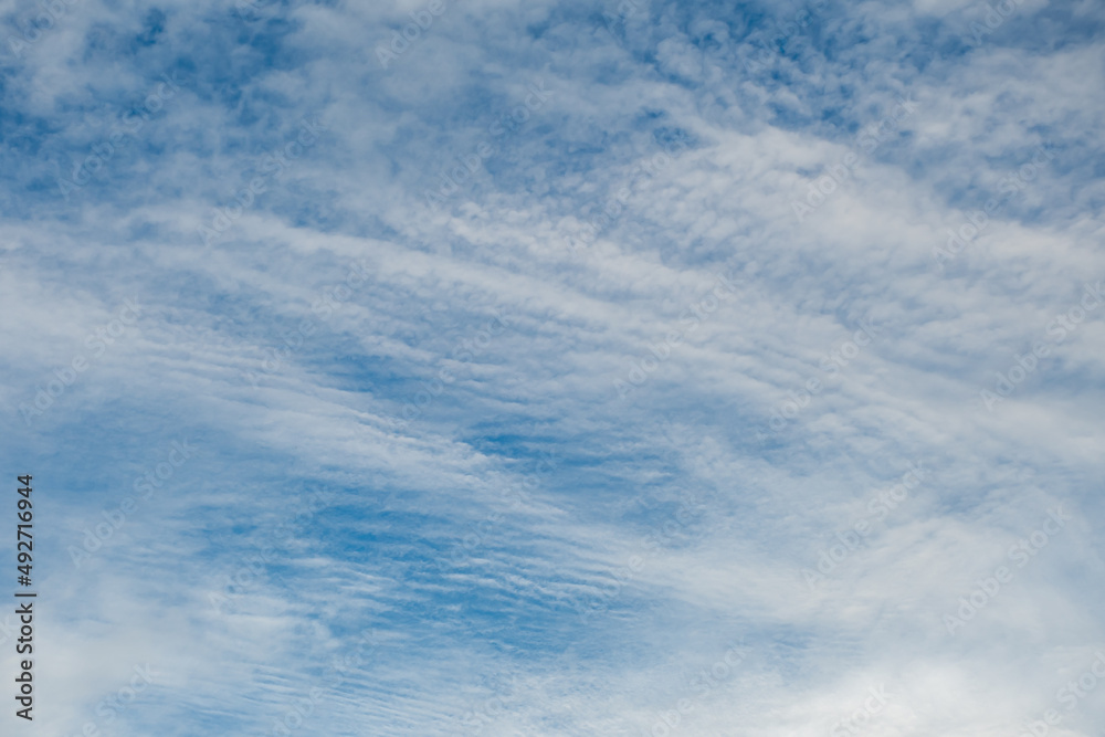 Many white fluffy clouds in blue sky in summer day background. Many white fluffy clouds in blue sky in summer day background.