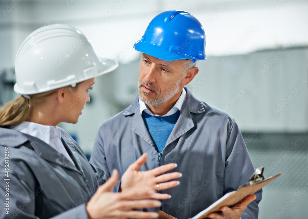 Communication takes practice. Two factory employees wearing hardhats having a discussion. Communication takes practice. Two factory employees wearing hardhats having a discussion.