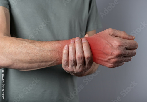 Wrist pain. Man hand closeup holding painful wrist. Health care concept. High quality photo