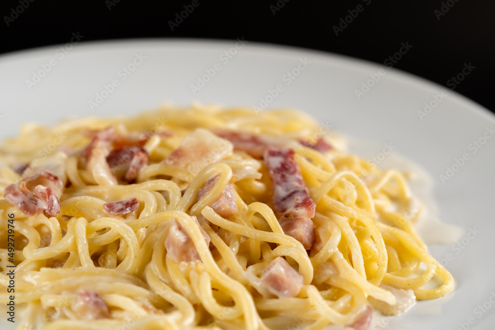 carbonara spaghetti with cream in white plate on balck backgroud carbonara spaghetti with cream in white plate on balck backgroud
