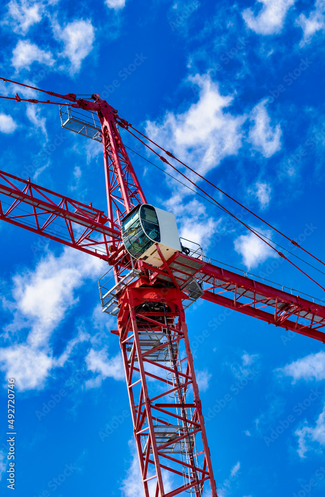 New construction site with crane on blue sky background. Steel frame structure, structural steel beam, construction business.