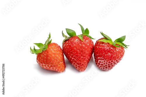 Strawberries isolated. Whole strawberries with leaves on a white background. Label for strawberry jam or refreshing summer strawberries. Close up side view