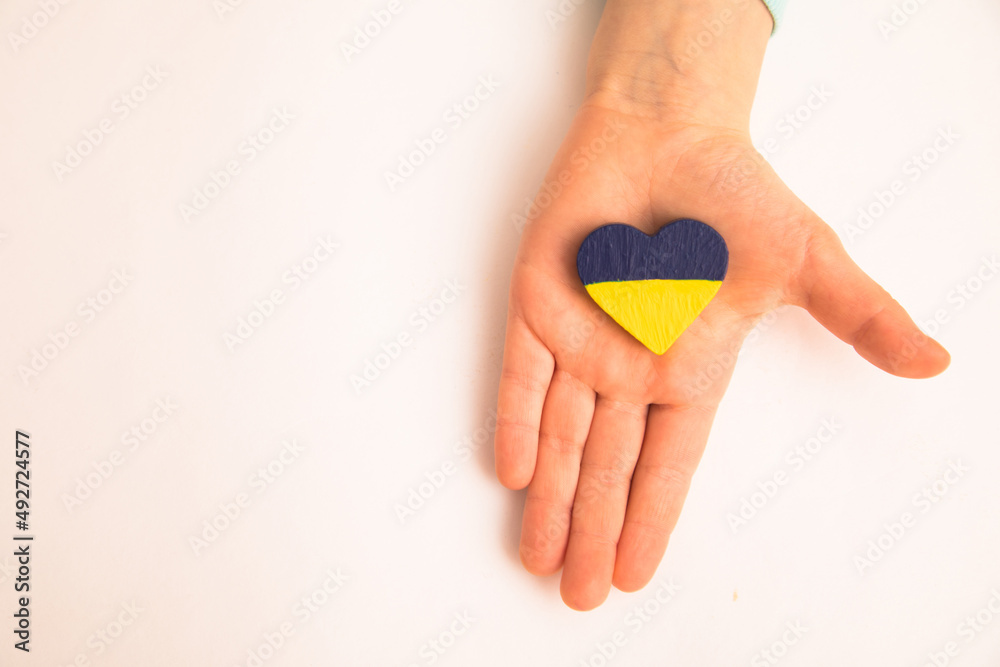 High angle view of child hands holding ukraine flag painted heart High angle view of child hands holding ukraine flag painted heart