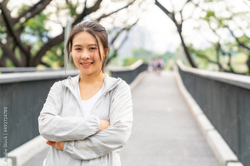 Portrait of Asian woman in sportswear jogging exercise at city public park in summer morning. Healthy wellness female athlete enjoy outdoor lifestyle activity sport training fitness running workout Portrait of Asian woman in sportswear jogging exercise at city public park in summer morning. Healthy wellness female athlete enjoy outdoor lifestyle activity sport training fitness running workout