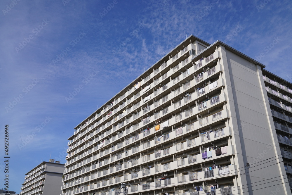 そびえ立つ昭和に建てられた古い団地、ファミリーマンション、青空に伸びる古いマンション、