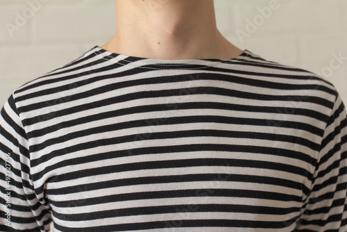 A young man in a sailor 's striped vest . photo