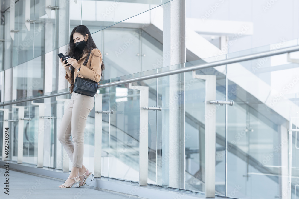 Asian woman walks up the elevator and plays with her mobile phone to shop in the mall. Asian woman walks up the elevator and plays with her mobile phone to shop in the mall.