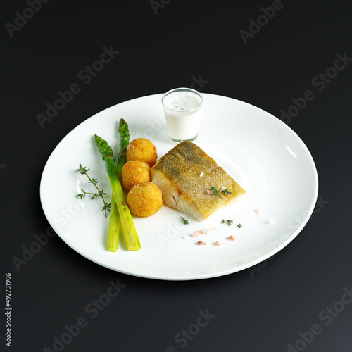 traditional dishes of European cuisine, delicacy, banquet snack. culinary dishes on a white plate on a black background. restaurant service photo