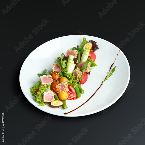 traditional dishes of European cuisine, delicacy, banquet snack. culinary dishes on a white plate on a black background. restaurant service photo