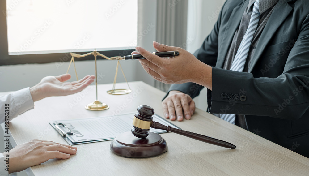 A man lawyer or a judge counseling clients about judicial justice and prosecution with scales, judges gavel, legal documents legal services concept A man lawyer or a judge counseling clients about judicial justice and prosecution with scales, judges gavel, legal documents legal services concept