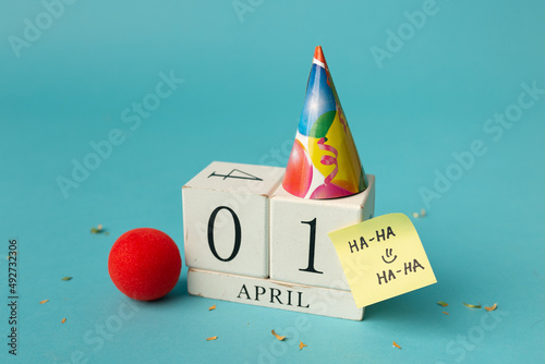 April 1st. Image of april 1 wooden calendar and festive decor on the blue background. April Fool's Day