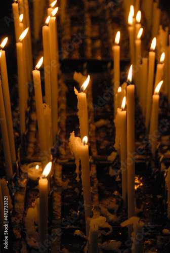 Yellow burning candles on a dark background
