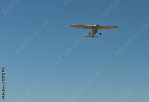 A lonely small plain flying off into a blue sky