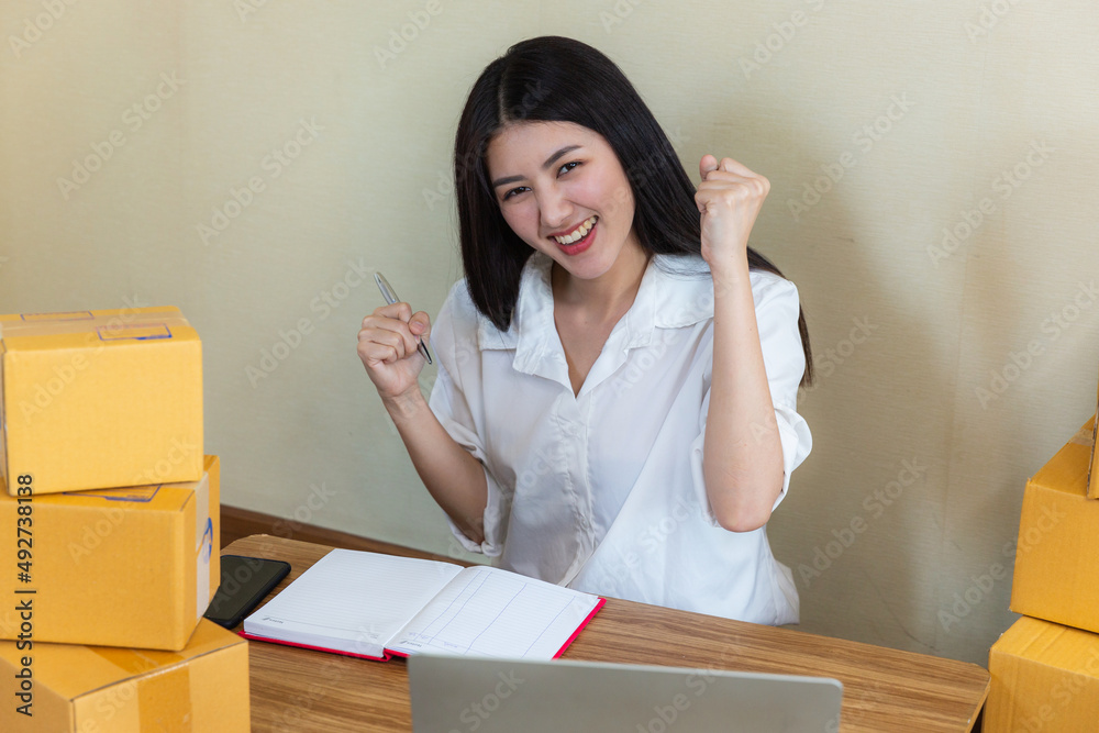 Asian young woman startup small business online at home and packing box for delivery online to customer. Asian young woman startup small business online at home and packing box for delivery online to customer.