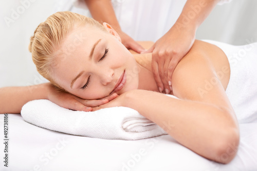 This masseuse has miracle hands.... A beautiful young woman enjoying a massage at a spa.
