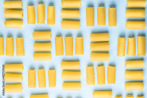 Fotografie Italian pasta rigatoni or maccheroni on the  blue background
