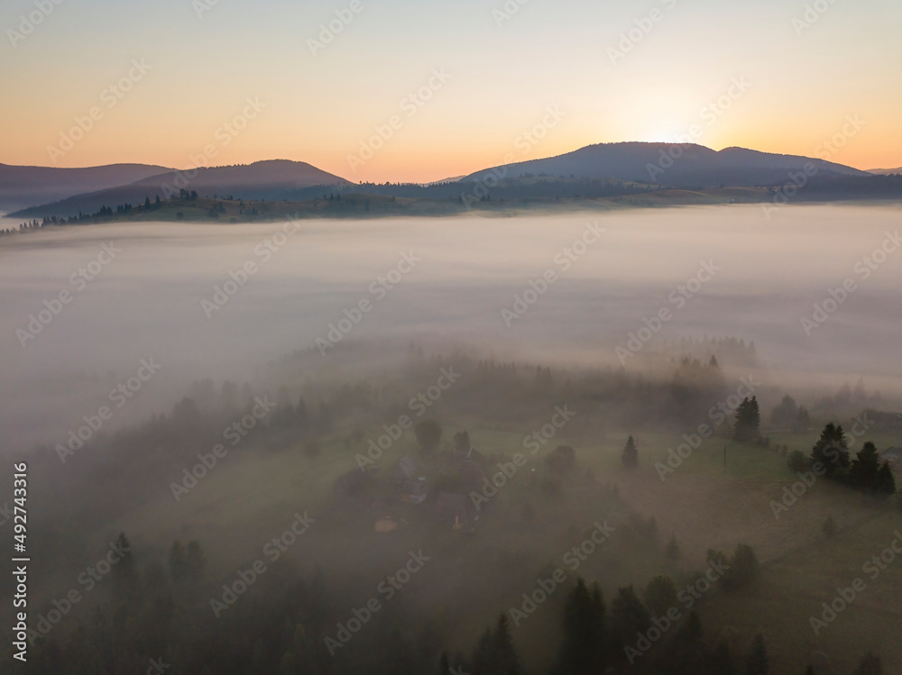 Sunrise over the fog in the Ukrainian Carpathians. Aerial drone view.