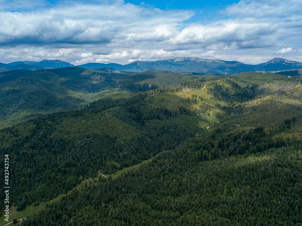 Green mountains of Ukrainian Carpathians in summer. Coniferous trees on the slopes. Aerial drone view. Green mountains of Ukrainian Carpathians in summer. Coniferous trees on the slopes. Aerial drone view.