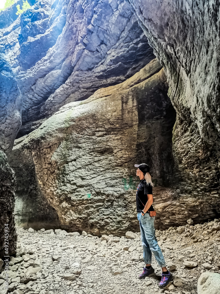 A girl in a canyon in a mountain gorge on the way to the Saltinsky waterfall. Russia Dagestan June 2021. A girl in a canyon in a mountain gorge on the way to the Saltinsky waterfall. Russia Dagestan June 2021.