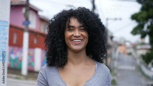 A happy Brazilian woman standing outside in urban street