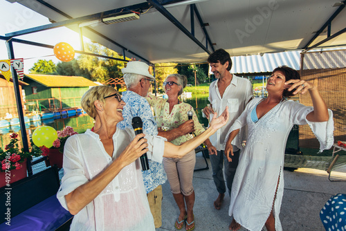 Wallpaper Mural Senior people singing karaoke celebrating birthday in the cottage on the river. Torontodigital.ca