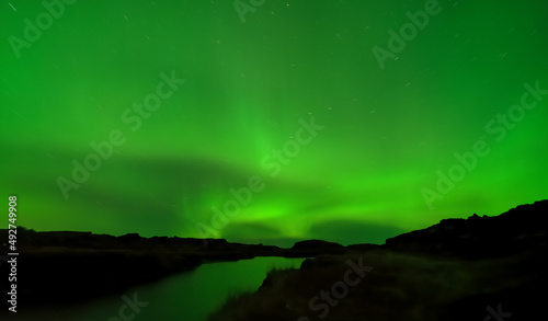Obraz na plátne Aurora borealis lights long expo with star trail and green sky