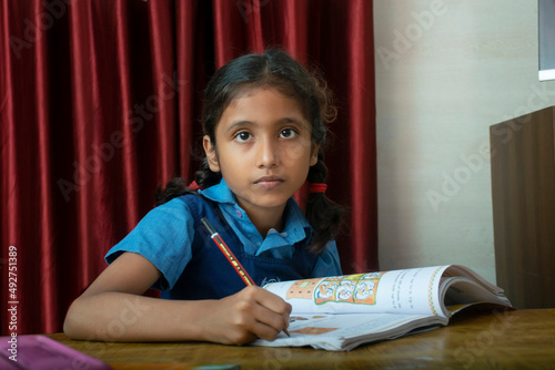 school girl writing with pencil photo