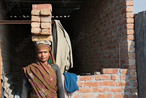 Portrait of a woman labourer holding bricks on her head