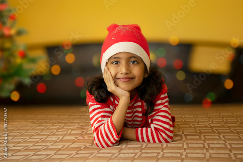 happy young girl wearing Santa s hat in Christmas eve photo