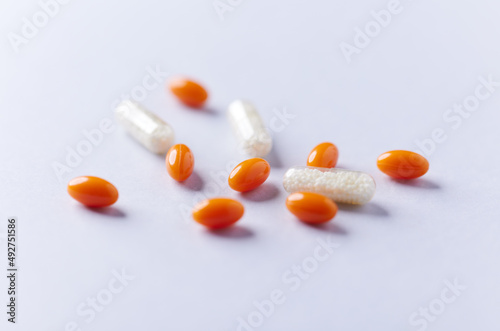Coenzyme Q10 and Vitamin C, capsules. Antioxidants. Concept for a healthy dietary supplementation. Bright paper background. Soft focus. Close up. Copy space. 