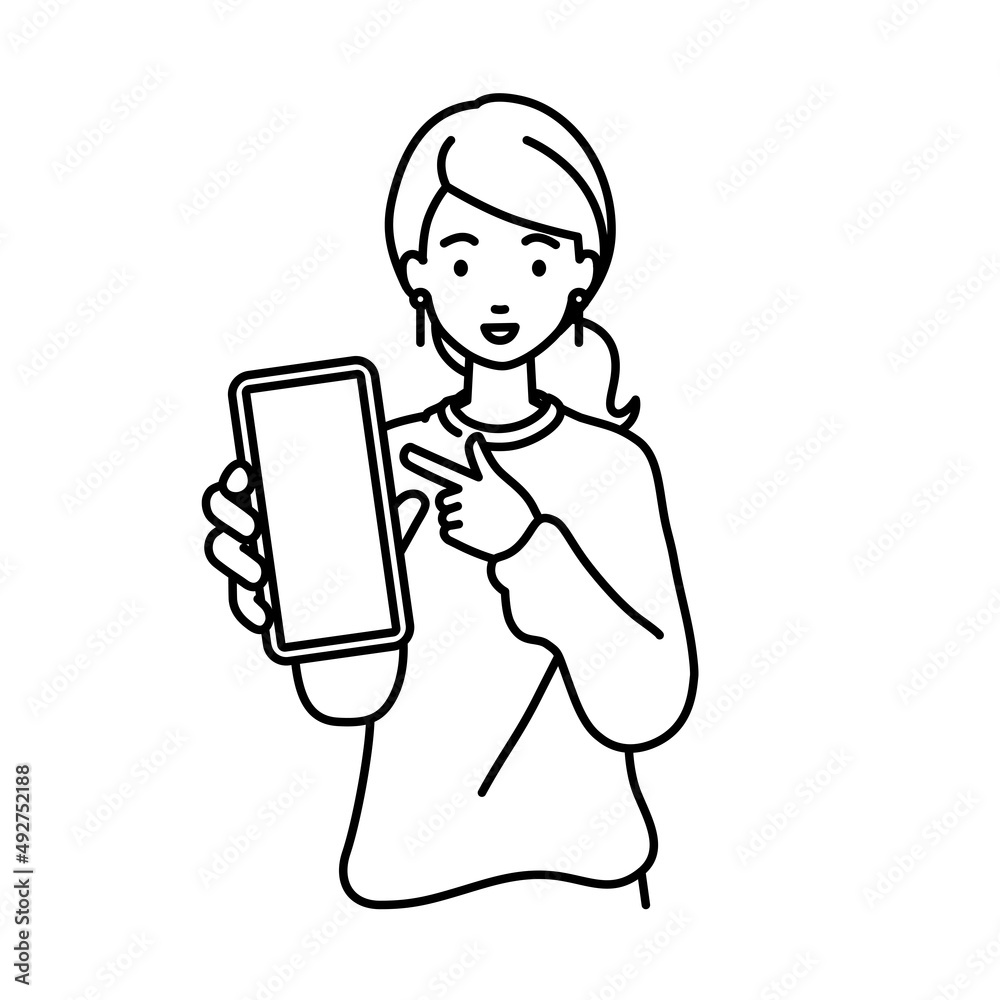 立ってスマートフォンを指差してこちらに向けて見せているリモートワークの女性 立ってスマートフォンを指差してこちらに向けて見せているリモートワークの女性