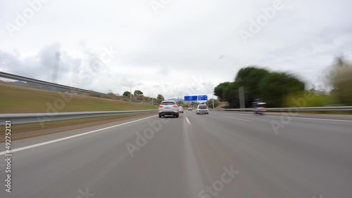 driving a car on the barcelona motorway highway in spain, fast camera mounted on the front time lapse with motion blur cloudy day photo