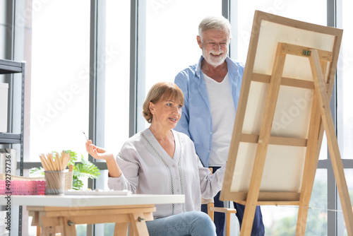 senior couple painting a picture from paintbrush in free time © offsuperphoto