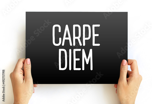 Carpe diem (latin language “seize the day”) phrase used by the Roman poet Horace to express the idea that one should enjoy life while one can, text on card