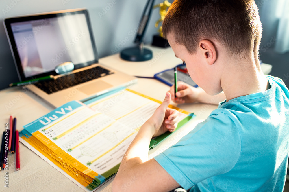 Boy sitting at the desk doing homework at home. Boy sitting at the desk doing homework at home.
