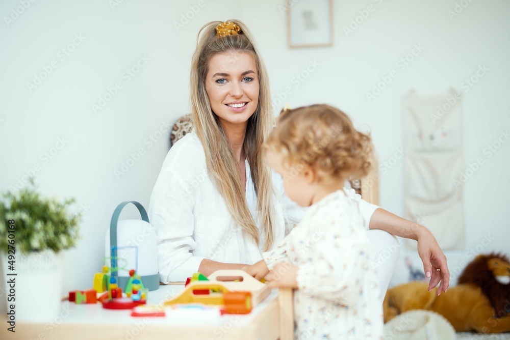 Young beautiful mother playing with her daughter at home. Young beautiful mother playing with her daughter at home.
