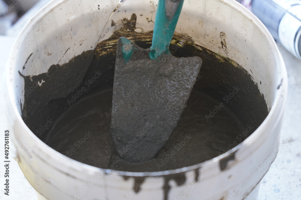 Mixing mortar in a white bucket. Working home. Mixing mortar in a white bucket. Working home.