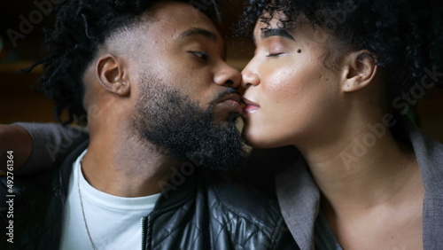 A young black couple kissing passionately
