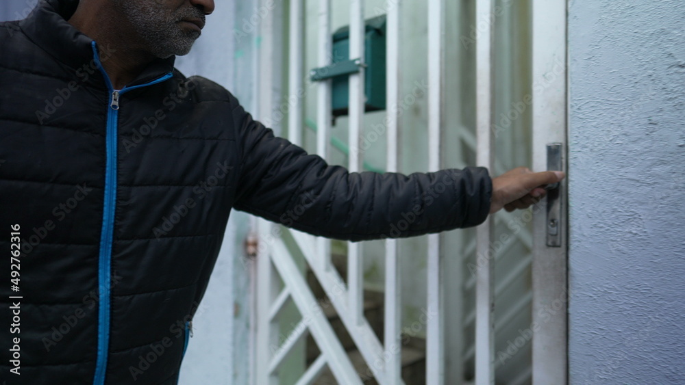 Person arriving home opening door a senior man opens entrance gate Person arriving home opening door a senior man opens entrance gate