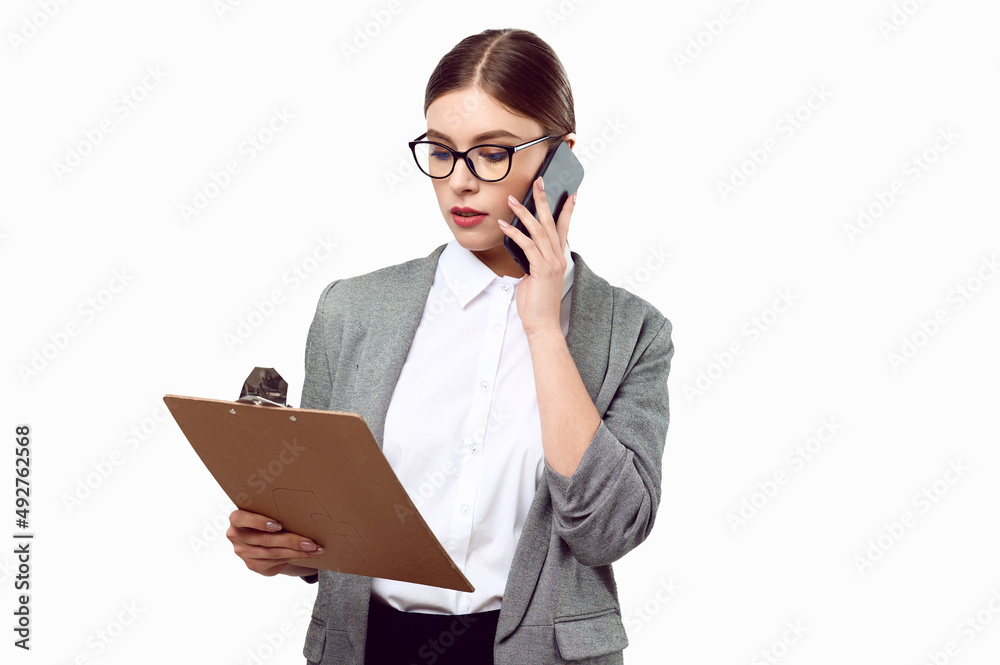 Young successful business woman in a jacket white shirts talking on the phone and holding a folder with documents tablet on a white isolated background Young successful business woman in a jacket white shirts talking on the phone and holding a folder with documents tablet on a white isolated background